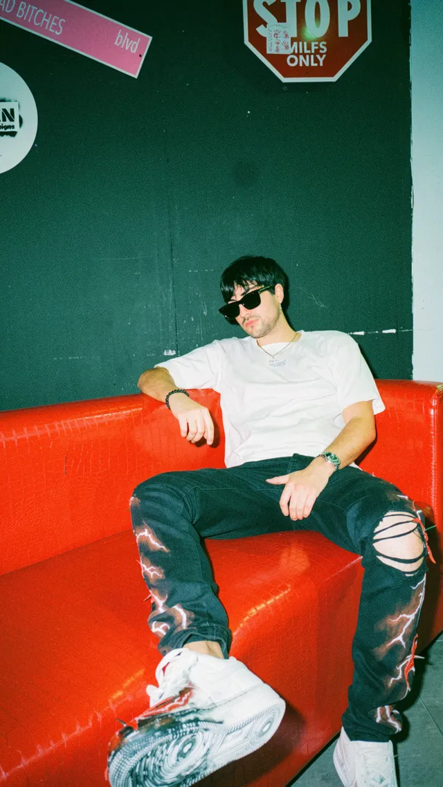 Thomas Deil backstage on a red sofa